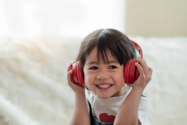 Photo of Happy Asian child enjoy listening to music with headphones