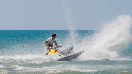 Young men cruising sea on a jet ski