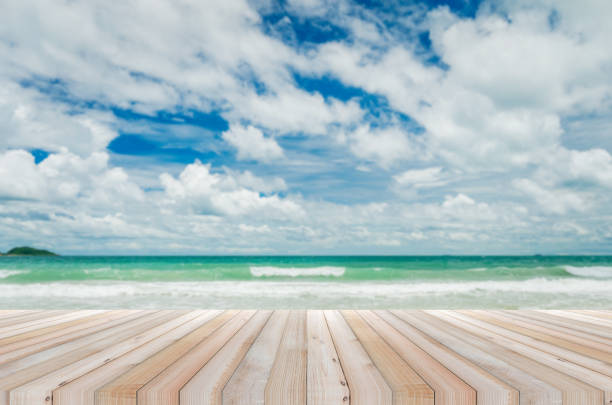 istock wood table with tropical beach and sea summer and blue sky with cloud background. beautiful floor copy space for design your products brand for ad. 1176360962