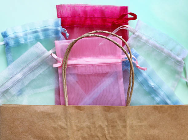 Organza bags and recycled eco bag on blue background. Organza bags can be used for storage different things for a long time. Waste zero reuse concept. Eco-friendly design stock photo
