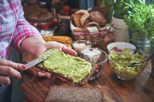 istock Preparing Avocado Sandwich with Brown Bread and Pomegranate 1176364312