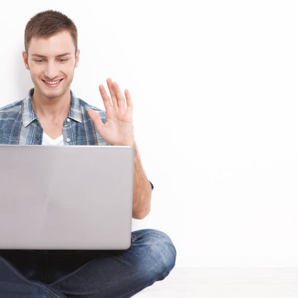 istock Young couple talking to each other via online video chat. Handsome man using a laptop for business and entertainment 1176371014