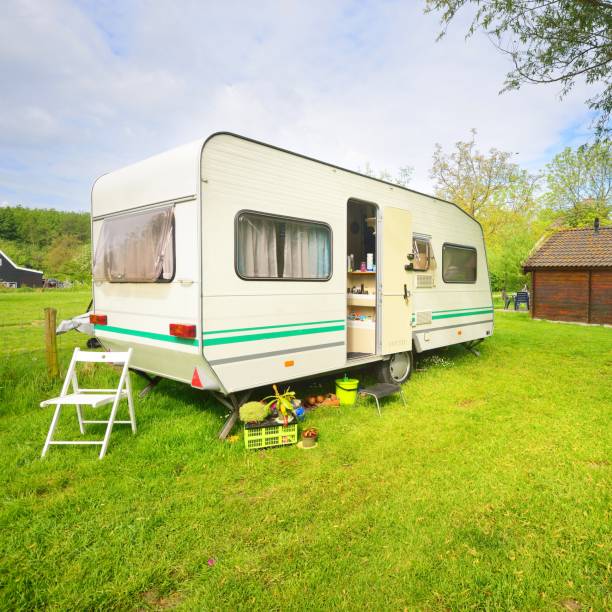 istock Caravan trailer camping on a green lawn under a tree in springtime 1176380514
