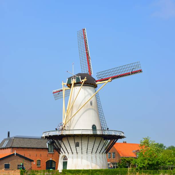 istock Classical Dutch landscape with a white windmill on a field against blue sky 1176380537