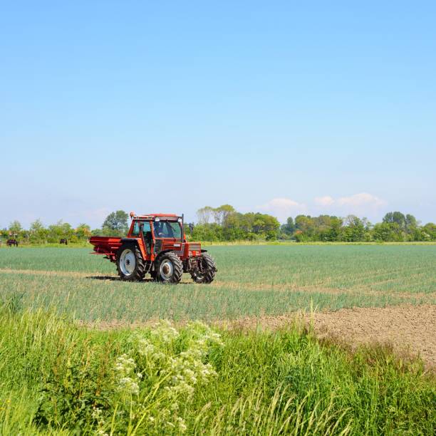 istock Red tractor working on a field in the Netherlands 1176380543
