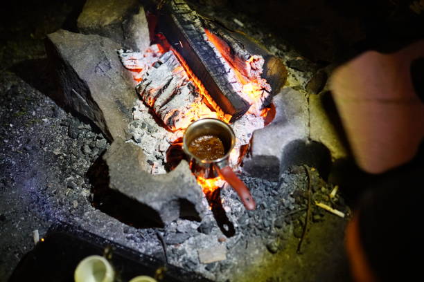 istock Boiling coffee in turkish cezva on campfire coals. Luxury camping concept. 1176386730