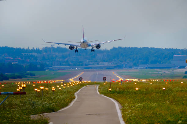 Airplane landing at airport runway, back view