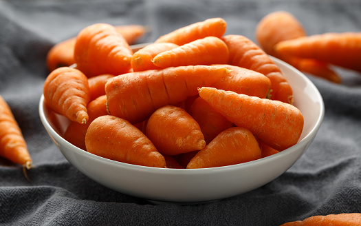 Mini chantenay carrots in a white bowl.