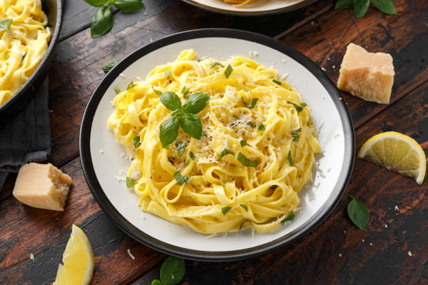 istock Pasta al Limone, Lemon with basil and parmesan cheese on wooden table 1176393778