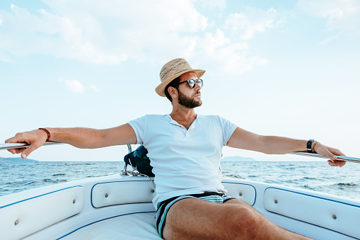 Young man enjoying and looking away on a yacht trip