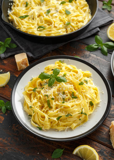 istock Pasta al Limone, Lemon with basil and parmesan cheese on wooden table 1176394000