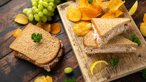 Healthy Tuna Sandwich with celery and onion on wooden board Healthy Tuna Sandwich with celery and onion on wooden board. tarragon cutting board vegetable herb stock pictures, royalty-free photos & images