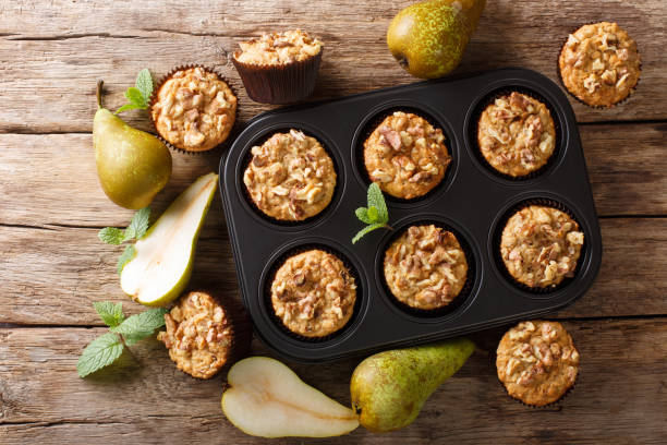 istock Only from the oven pear muffins with walnuts, cinnamon and nutmeg in a baking dish close-up. Horizontal top view 1176394576