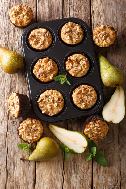 istock Autumn vegetarian pear muffins with walnuts in a baking dish close-up. Vertical top view 1176395926