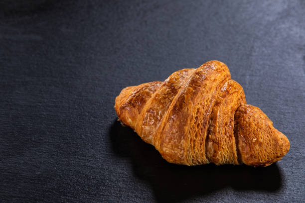 istock Croissant on black stone plate 1176395937