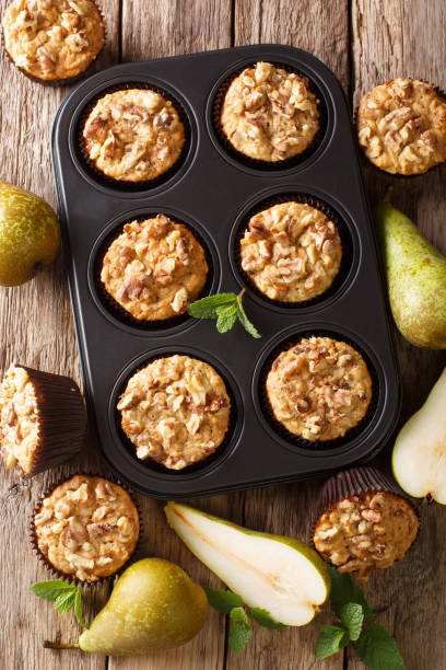 istock Freshly baked pear muffins with cinnamon and walnuts in a baking dish close-up. Vertical top view 1176395957