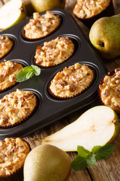 istock pear muffin with cinnamon and walnuts in a baking dish close-up. vertical 1176396027