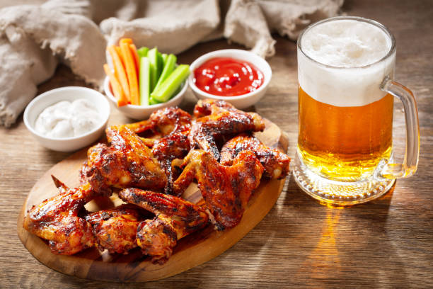plato de alitas de pollo a la parrilla y taza de cerveza - beer wing spicy chicken wings chicken wing fotografías e imágenes de stock