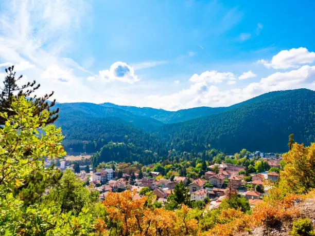 Scenic view of a mountain valley in autumn. Colourful countryside landscape with mountain forests and traditional houses. Balkan SPA capital Velingrad in Rhodope mountains