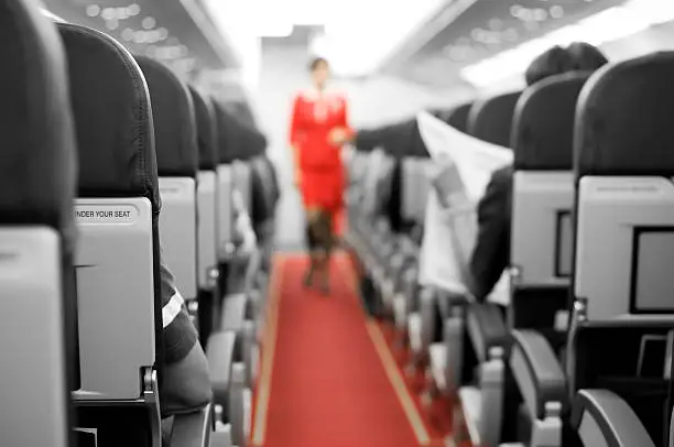 Air Travel with seats and cabin crew in background - Inside the plane