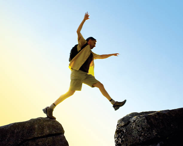 istock Man Jumping Rock to Rock on Mountain Top 117640453