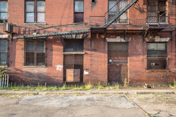 grande escape de incêndio do metal na parte traseira de um edifício de tijolo do vintage em uma cidade rural pequena - poverty ugliness residential structure usa - fotografias e filmes do acervo