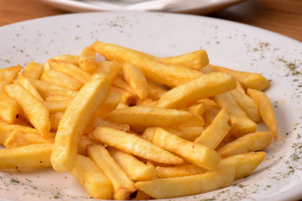 Simple portion of french fries on a plate on a white background, these without sauces ready to serve.
