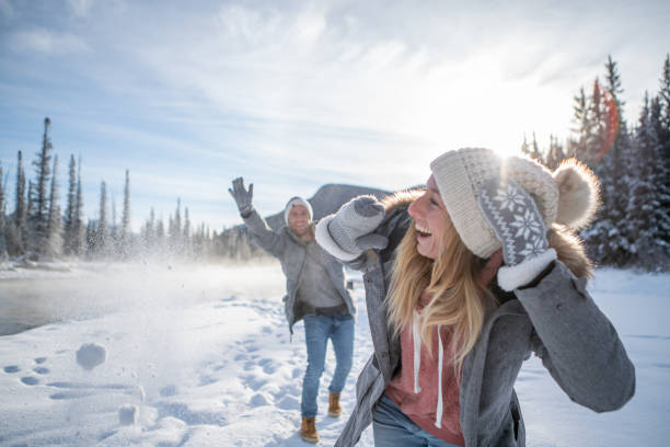 istock Playful couple snowball fighting in winter 1176409215