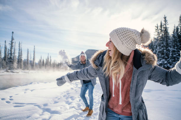 istock Playful couple snowball fighting in winter 1176409519