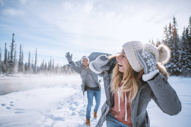 istock Playful couple snowball fighting in winter 1176410140