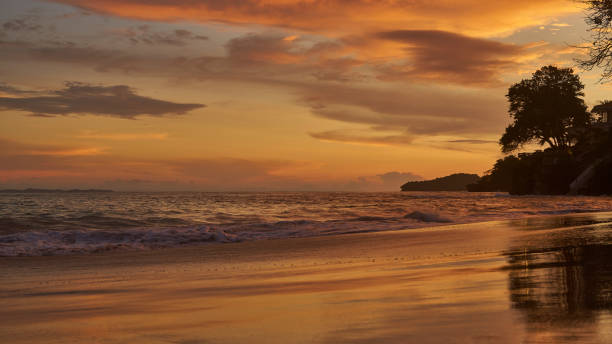 Golden sunset on the beach Playa Cacique of Contadora island in the Pacific Ocean stock photo