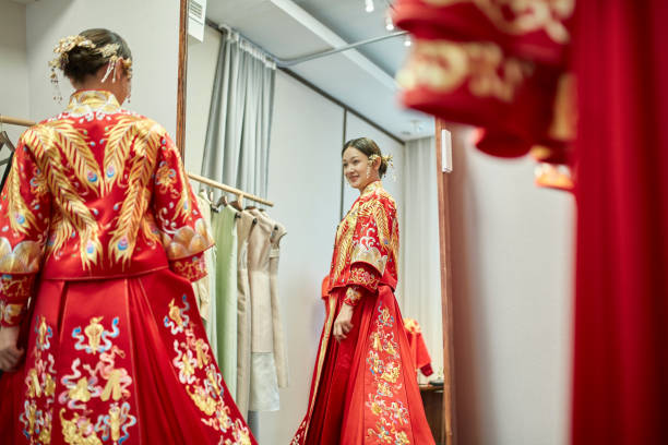 sorridente sposa cinese che prova su qun gua in designer studio - asian culture dragon textile symbol foto e immagini stock