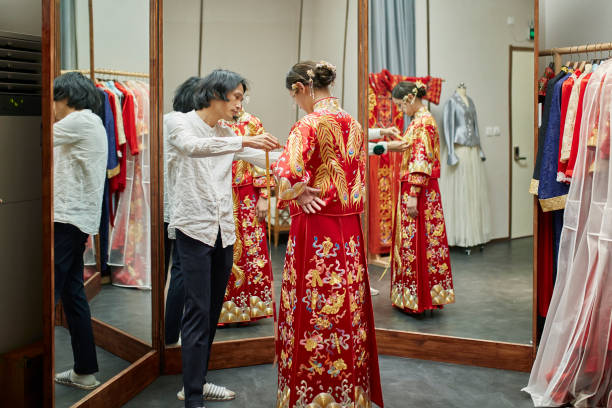 diseñador de vestidos chino poniendo toques finales en qun gua - asian culture dragon textile symbol fotografías e imágenes de stock