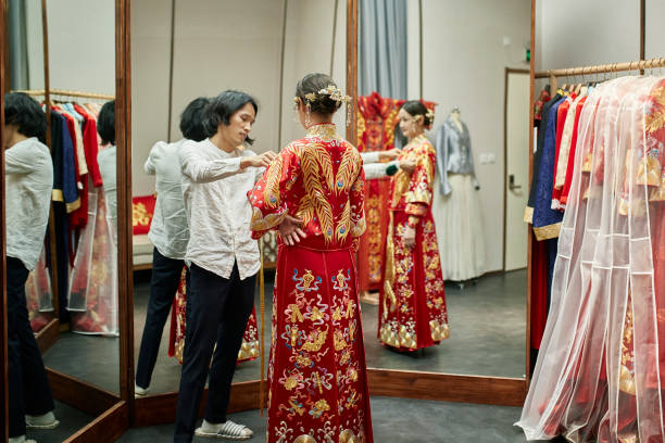 chinois dress designer mesurant qun gua veste sur la mariée - asian culture dragon textile symbol photos et images de collection