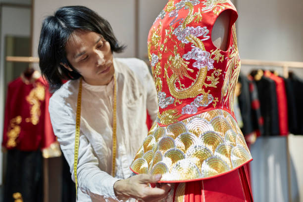 homme qun gua designer examining peplum sur le modèle de dressmaker - asian culture dragon textile symbol photos et images de collection