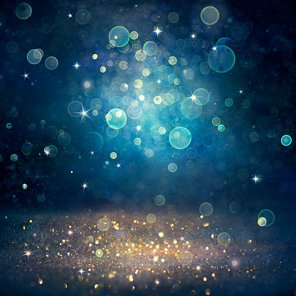 Navidad desenfocada - Polvo de brillo dorado sobre fondo azul photo