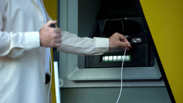 cieco alla ricerca di jack audio nel bancomat parlanti, usando le cuffie per prelevare denaro - human settlement audio foto e immagini stock