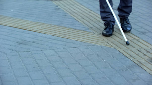 istock Blind man finds turn on tactile paving using walking stick, urban navigation 1176425387