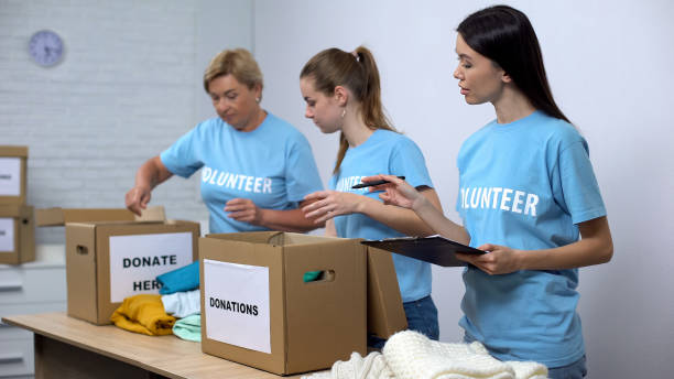 istock Volunteers putting clothes in donation boxes, social worker making notes charity 1176426286