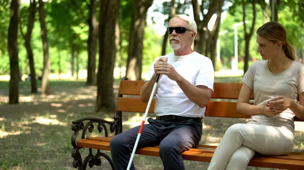 vieil homme aveugle s'asseyant sur le banc près de la fille mécontente impolie, ignorance humaine - falling people tripping senior adult photos et images de collection
