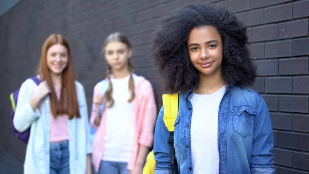 istock Cute female pupils smiling camera, friendly atmosphere, college campus education 1176426785