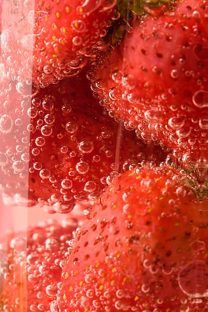 Macro strawberries in glass with water stock photo