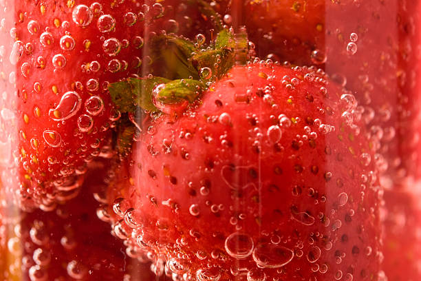 Macro strawberries in glass with water stock photo