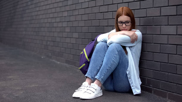 istock Desperate college student sitting school backyard, puberty age insecurities 1176426964