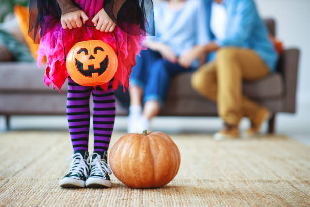 concept of halloween. child girl legs in witch costume with pumpkin - halloween witchs hat witch autumn imagens e fotografias de stock