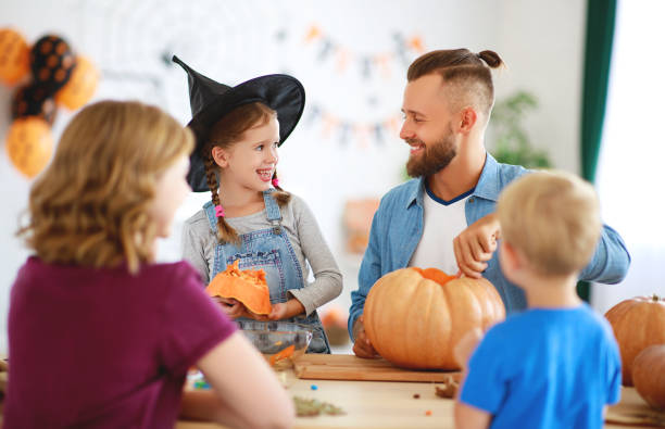 joyeux halloween! père de famille mère et enfants coupé citrouille pour des vacances à la maison. - spider mum photos et images de collection