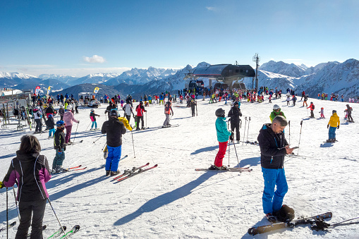 Kronplatz, Italy - February 13, 2018: Hundreds of skiers meet on the the Kronplatz Ski Resort Plateau in Alto Adige, Italy. This is a section of the large plateau of the ski area where many ski slopes start.  Kronplatz is the premier ski resort in South Tyrol.