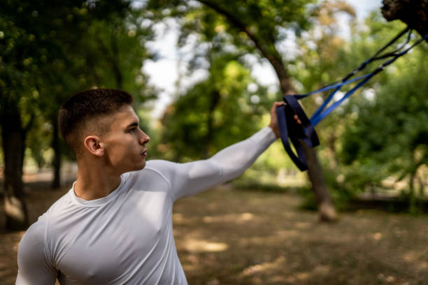 istock Young man workout on suspension straps outdoors 1176430027