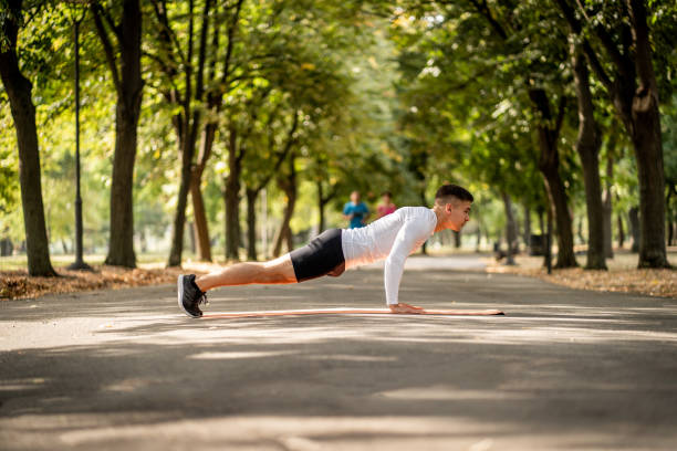 istock Fitness man doing push ups in park 1176434248