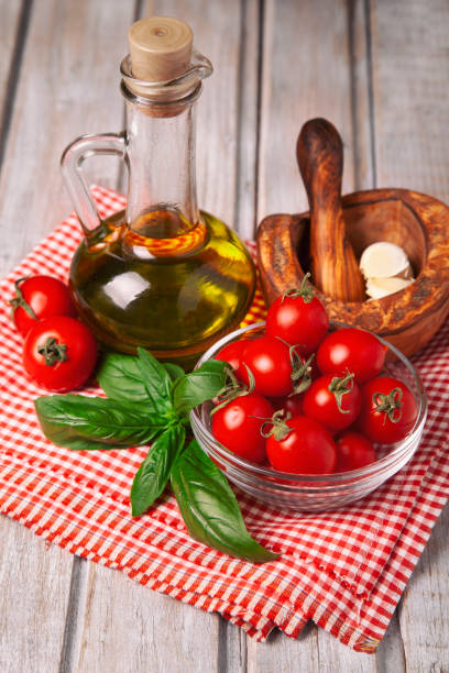 istock Cherry tomato, basil, olive oil and garlic on rustic wooden background 1176435777